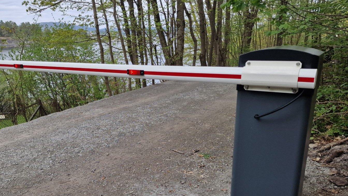 Elektrisk veibom med bomhus ved grusvei